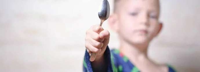 Un chico con una cuchara de plata