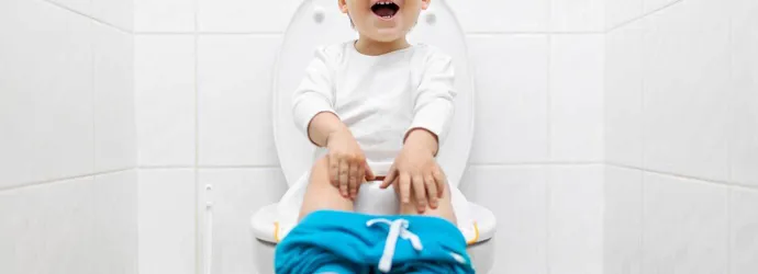 Niño sentado aprendiendo a hacer caca