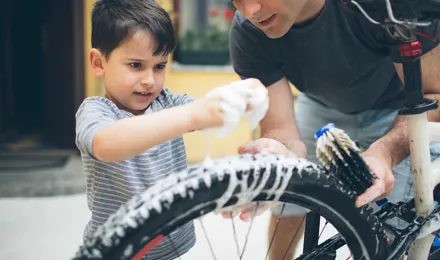 Pai e filho a limpar uma bicicleta