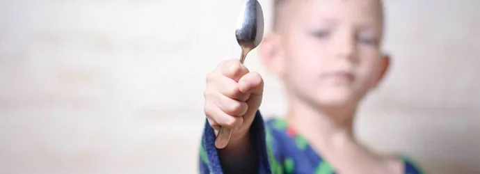 Um jovem a segurar uma colher de prata