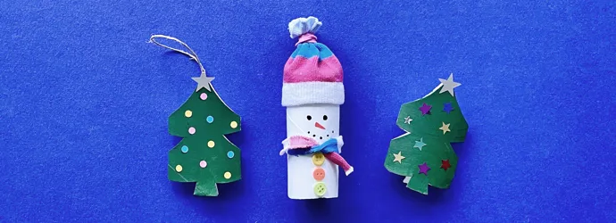 Una madre y su hija pequeña haciendo manualidades con rollos de papel higiénico para Navidad.